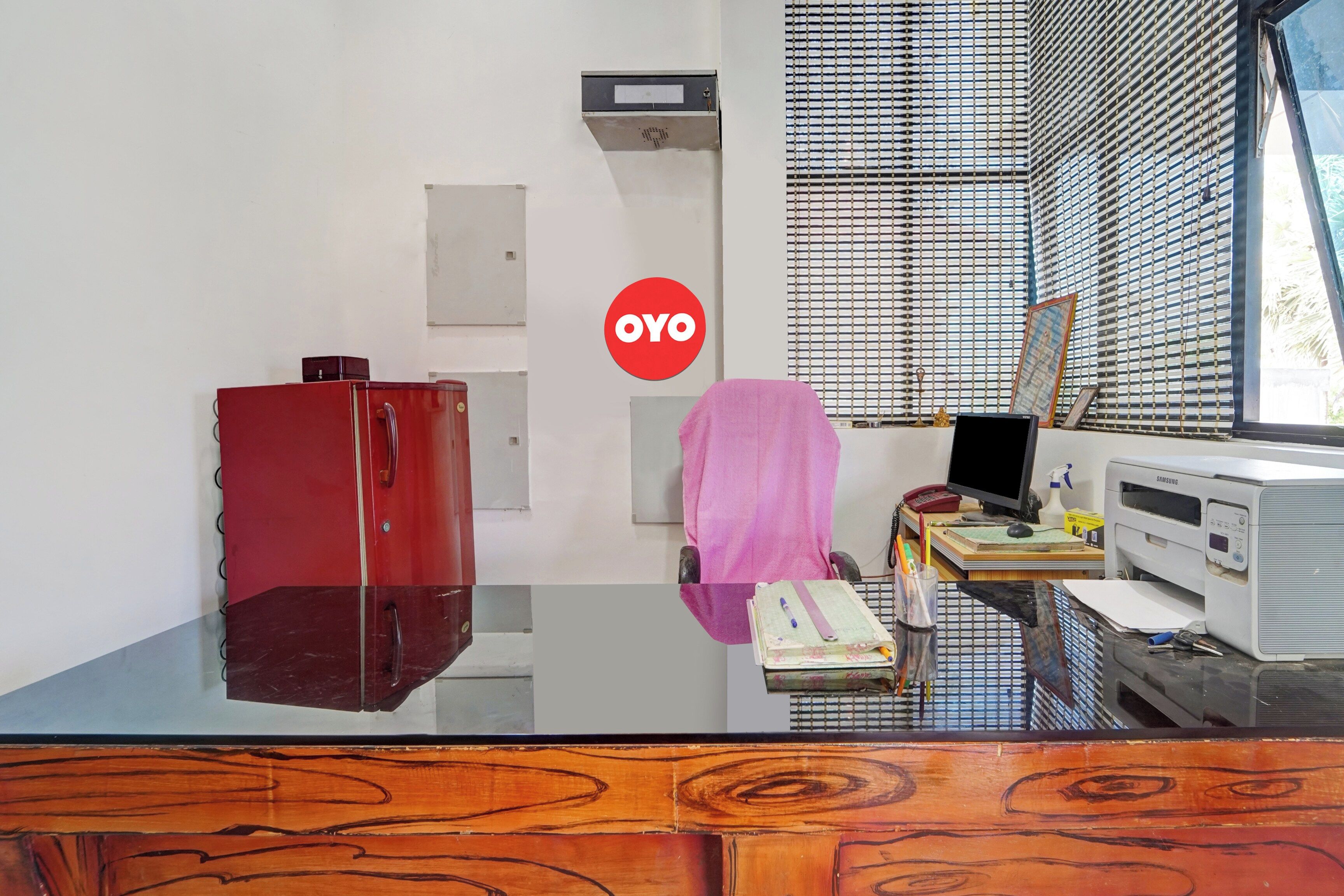 A room with a desk, a computer, a printer, and a red cabinet.