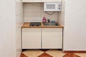 A compact kitchen with a microwave, sink, and a small countertop. - Curtain Call Vienna 1BR near Stadthalle (Vienna)