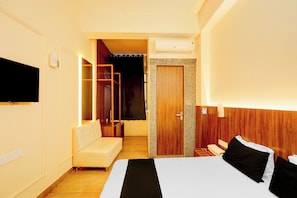 A hotel room with a bed, a sofa, a wardrobe, and a television. - Hotel O KEASARIYA SWEETS (Meerut)