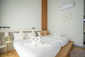 A modern hotel room with two beds, a large window, an air conditioning unit, and a wall clock. - Phuttho Pool Villa Khaokho (Khao Kho District)