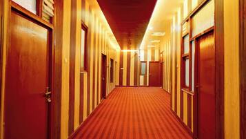 Un pasillo de hotel con puertas de madera y piso alfombrado.