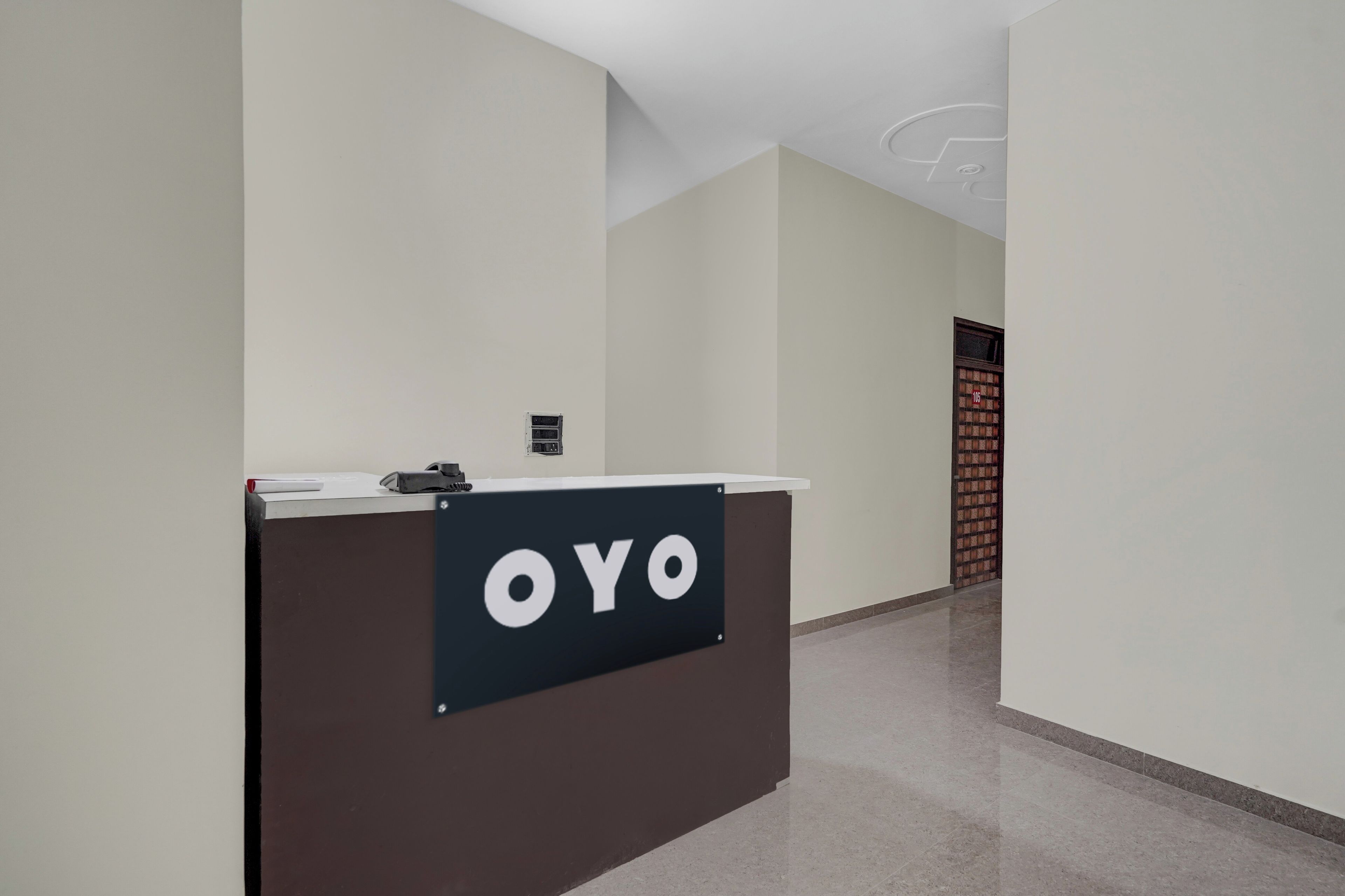 A reception desk with a sign that reads 'OYO' in a modern hotel lobby.