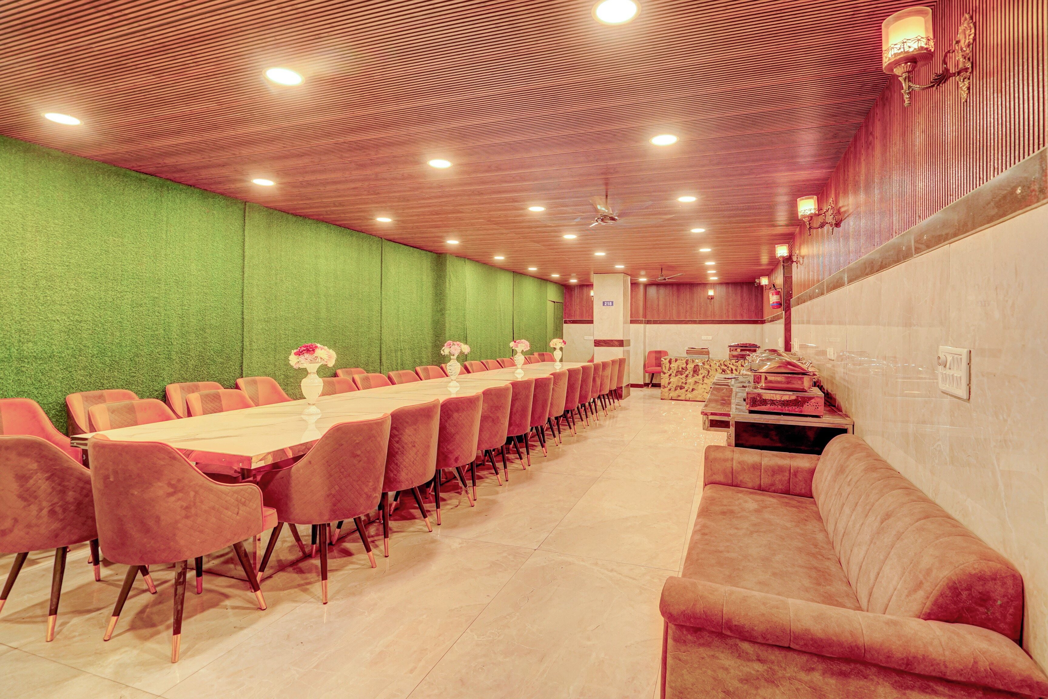 Un salón de conferencias con una larga mesa y sillas, una pared verde y un techo rojo.