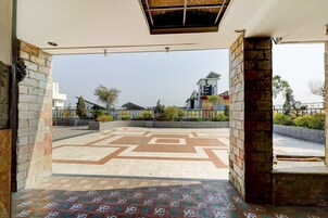An open courtyard with patterned flooring, a view of the surrounding buildings, and a clear sky.