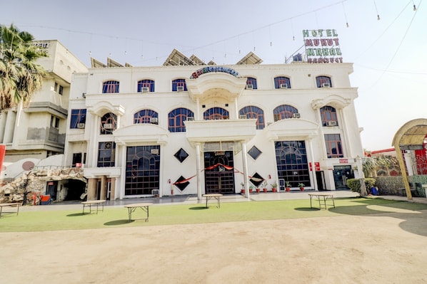 A hotel with a central entrance, multiple windows, and a sign for the reception.