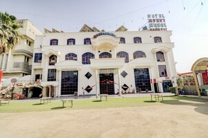 A hotel with a central entrance, multiple windows, and a sign for the reception.