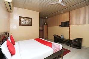 A hotel room with a bed, a television, a desk, and a wardrobe.