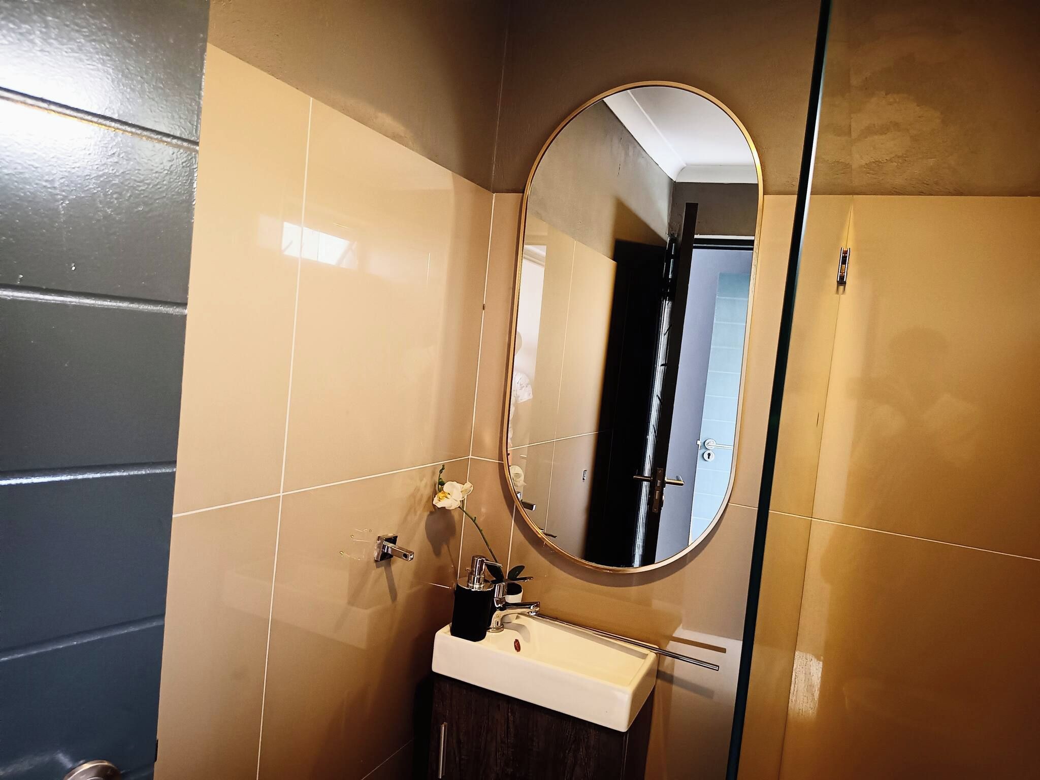 A bathroom with a white sink, a mirror, and a towel rack.
