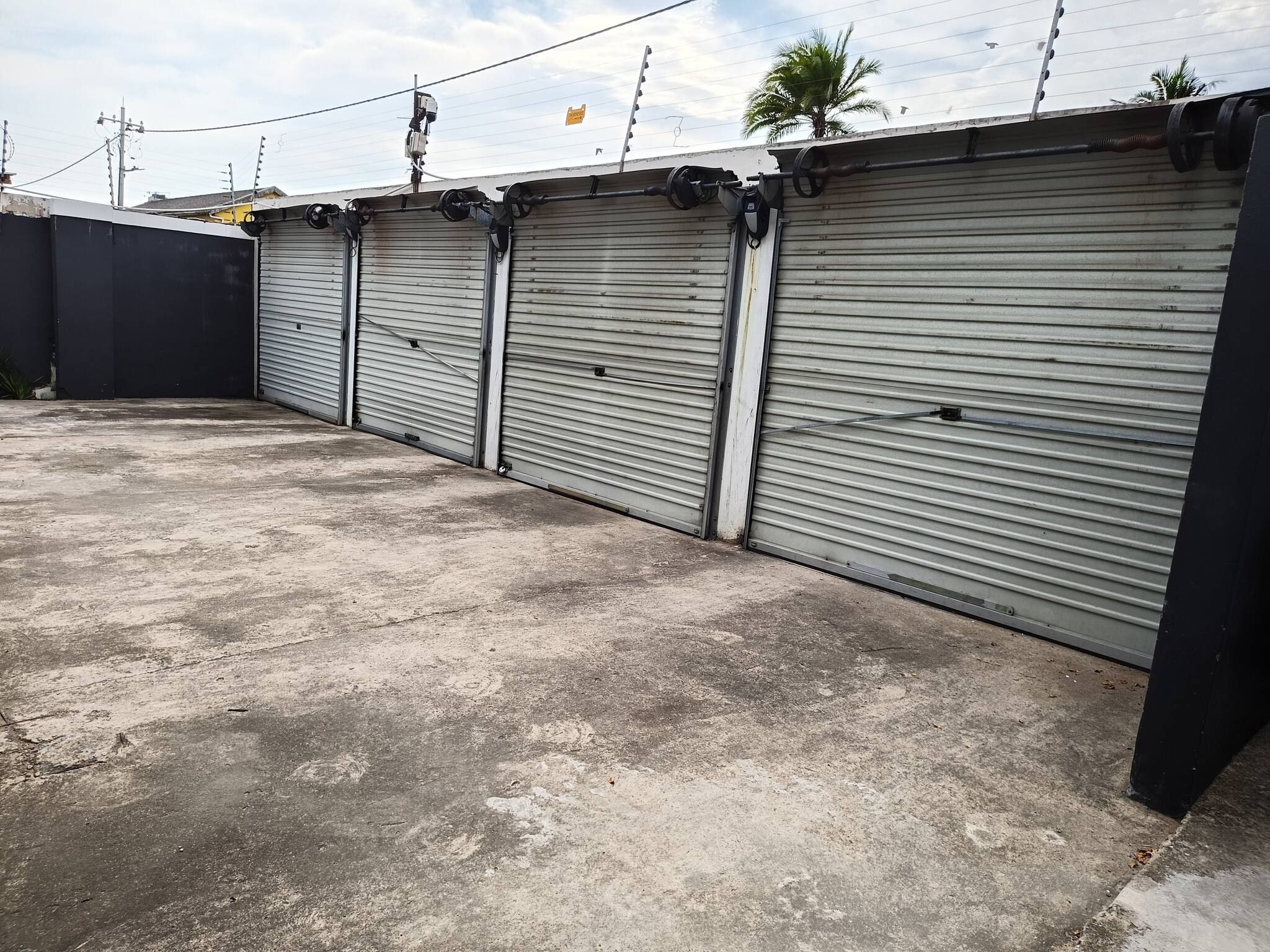 Una hilera de persianas metálicas cerradas, probablemente para un edificio comercial o industrial.
