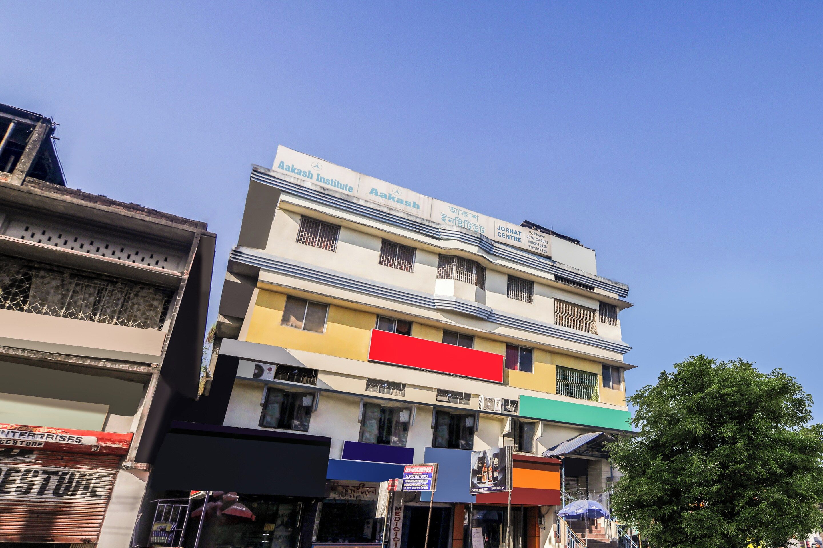 A multi-story building with signage for Aakash Institute and Jorhat Centre.
