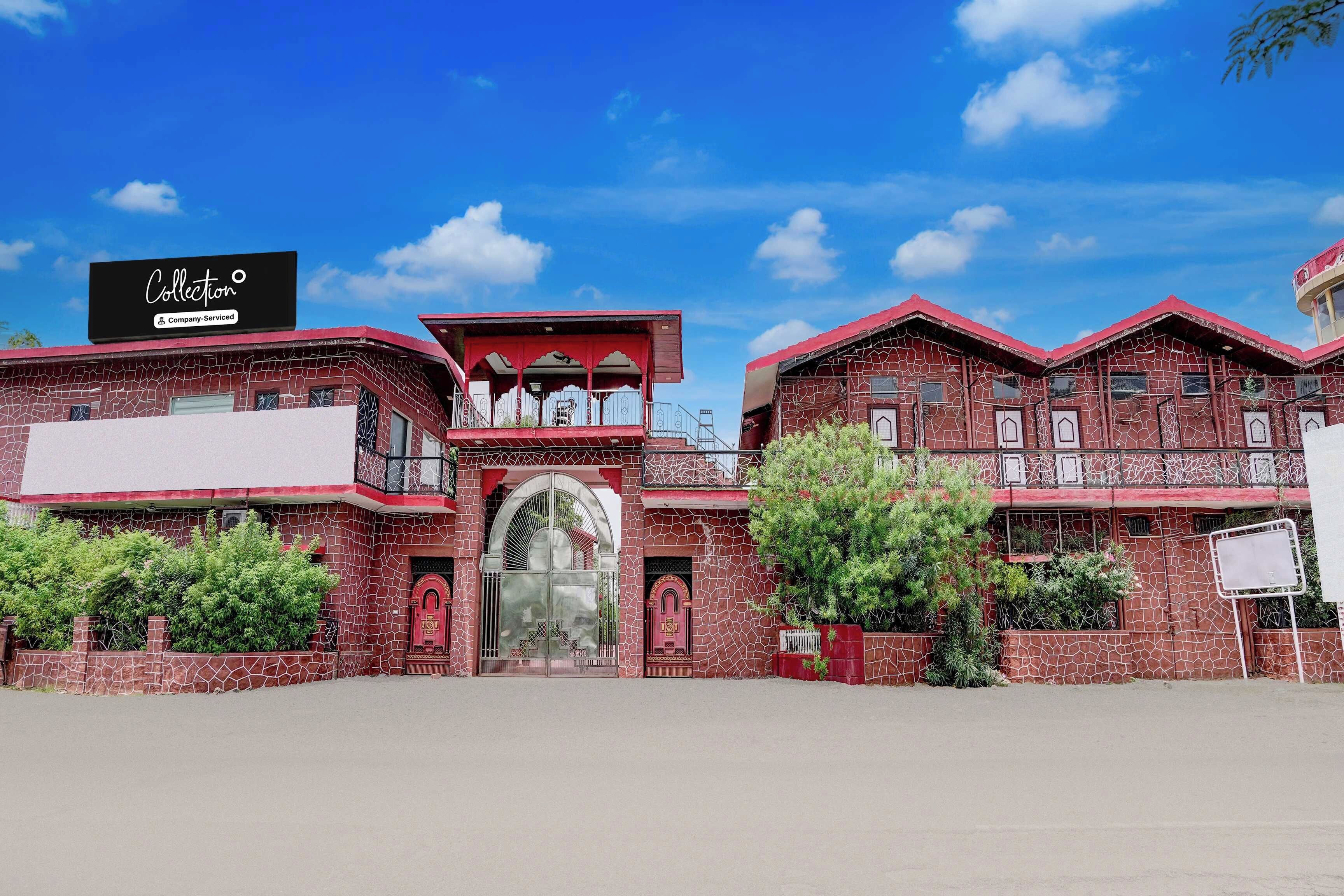 A building with a large arched entrance, multiple balconies, and a signboard.