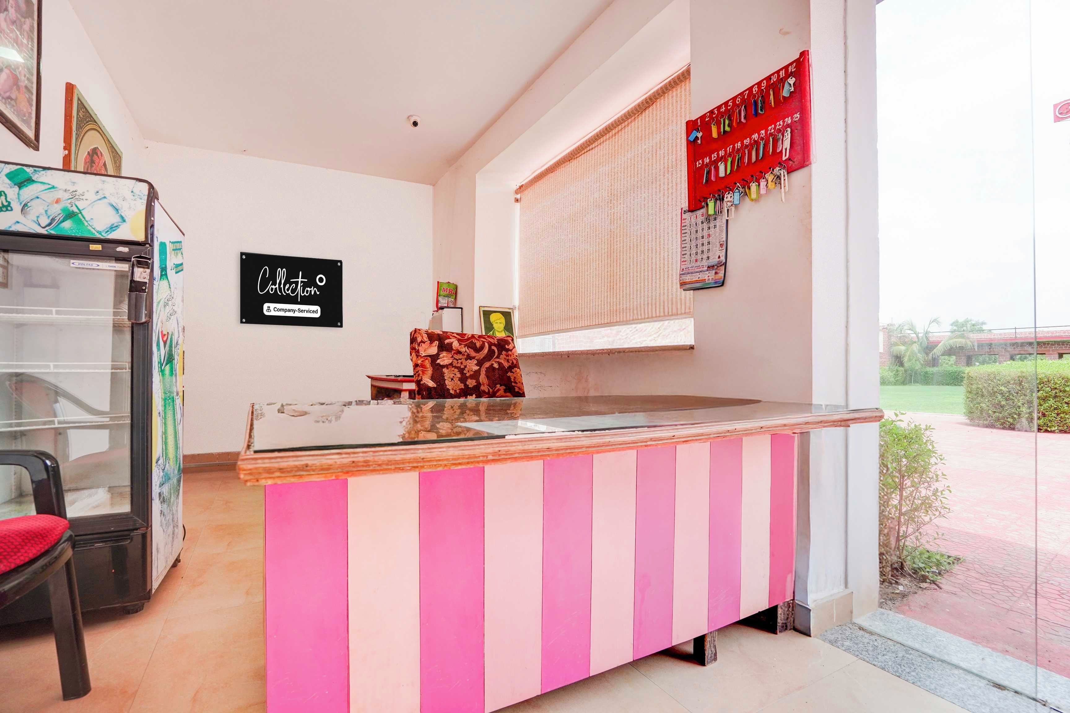 A reception desk with a pink and white striped design, a glass top, and a calendar on the wall.