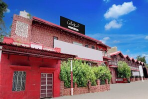 A building with a red facade, a black signboard, and a clear blue sky. - Collection O Rampura Rawat Resort (Jodhpur)