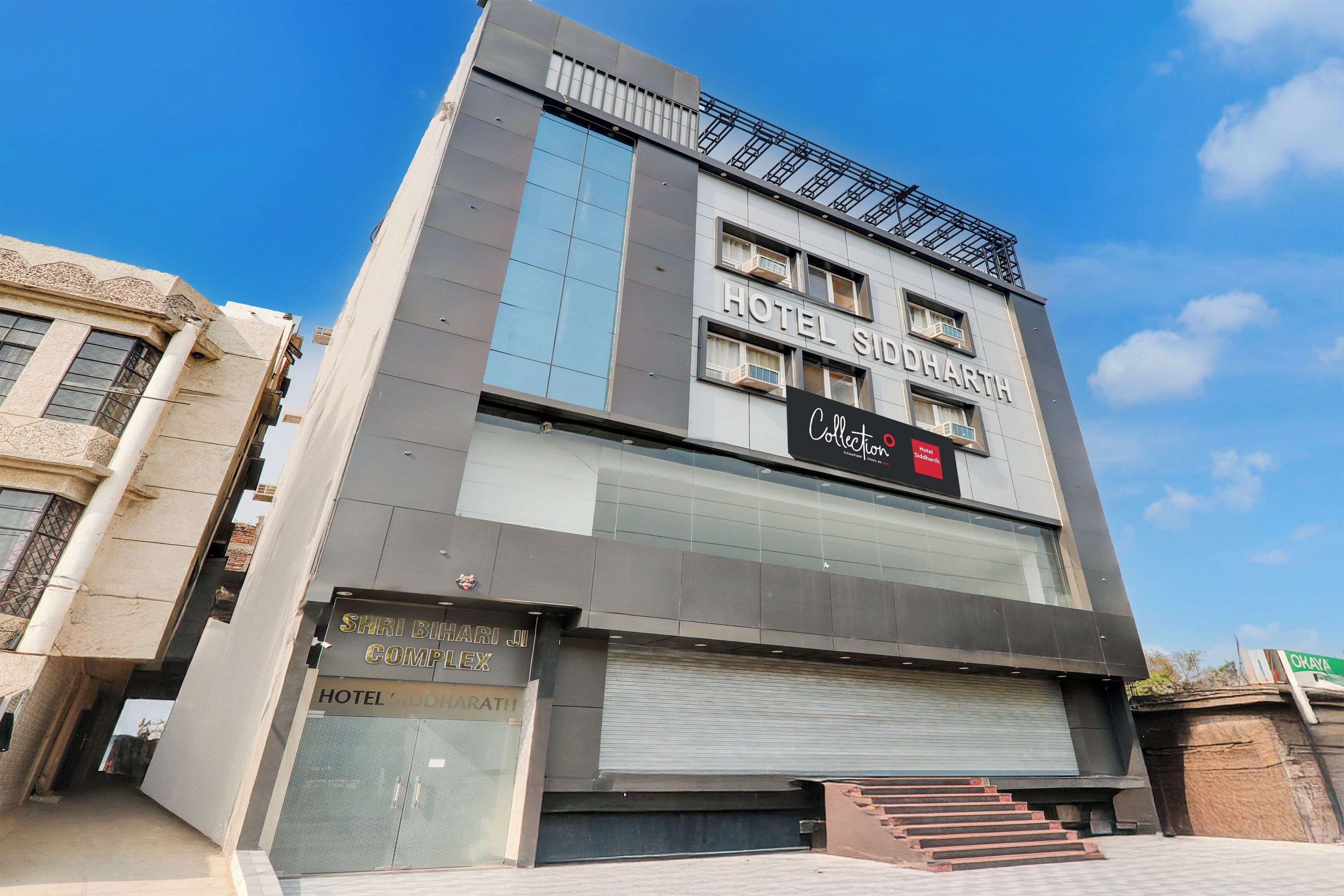 A modern hotel with a prominent sign for 'Hotel Siddharth' and a visible entrance.