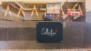 A reception desk with a sign that reads 'Collection Signature Stays by OYO.'