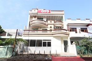 Un edificio de dos pisos con un letrero grande de 'OYO' en la parte superior.