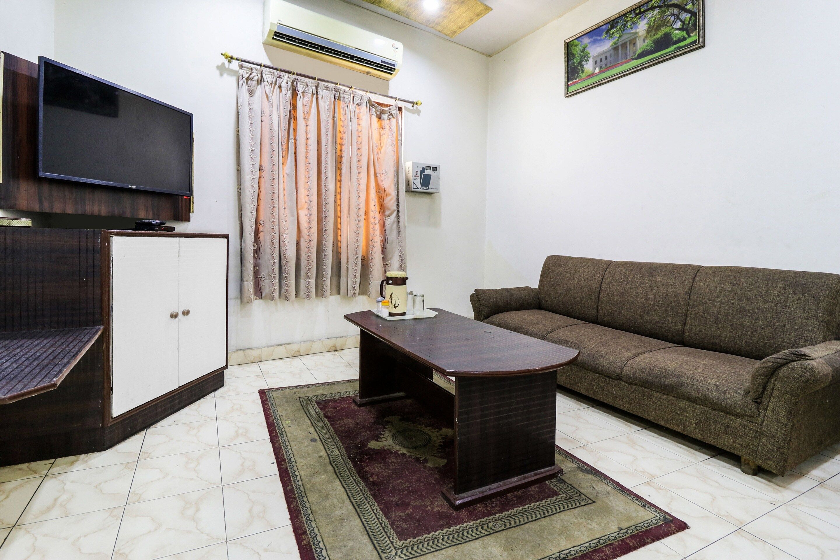 A living room with a sofa, a coffee table, a TV, and a cabinet.
