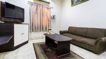 A living room with a sofa, a coffee table, a TV, and a cabinet.