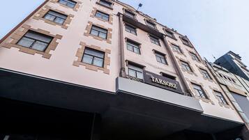 A multi-story building with a prominent sign for 'Hotel Takson' on the facade.