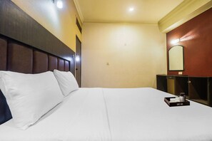 A hotel room with a large bed, a nightstand, a mirror, and a tray with a coffee pot and cups. - Townhouse Hotel Taksonz (Ludhiana)