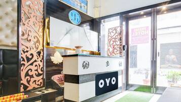 A reception desk with a logo, a sign with a symbol, and a door with a sign.
