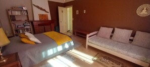 A bedroom with a bed, a sofa, a bookshelf, and a door leading to another room. - New Listing (Saint-Jean-du-Gard)