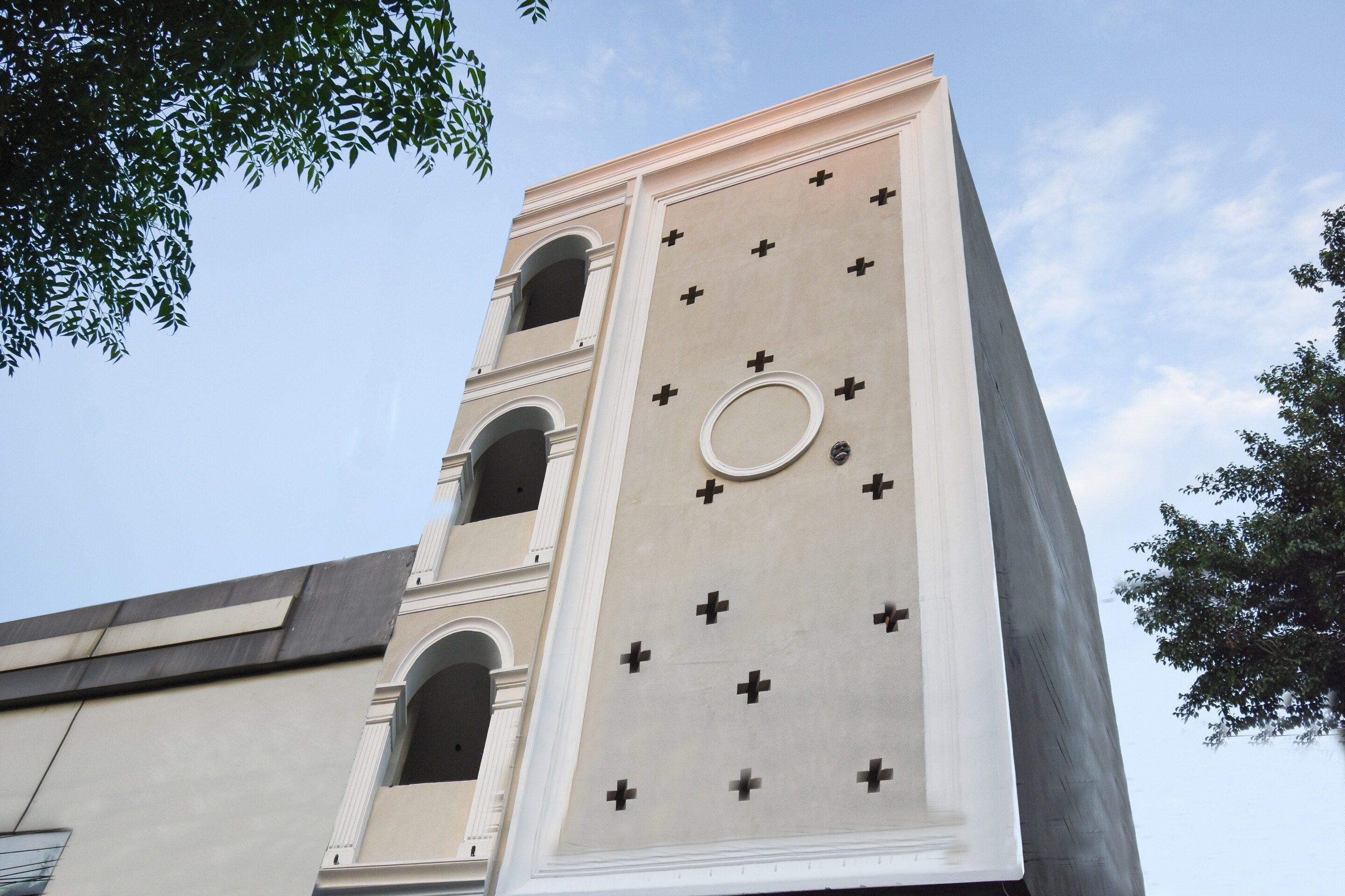 A building with a clock tower featuring a circular window and multiple balconies.
