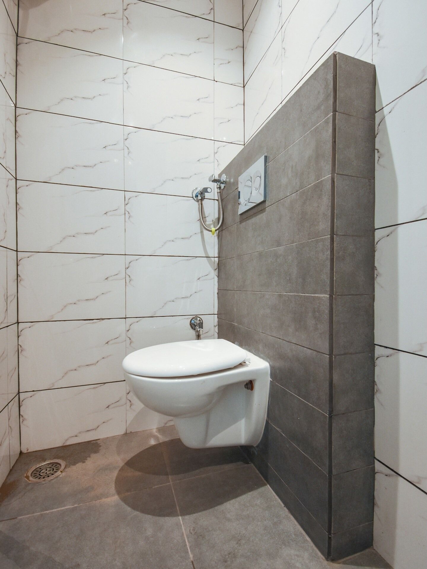 A bathroom with a toilet, a shower, and a wall-mounted mirror.
