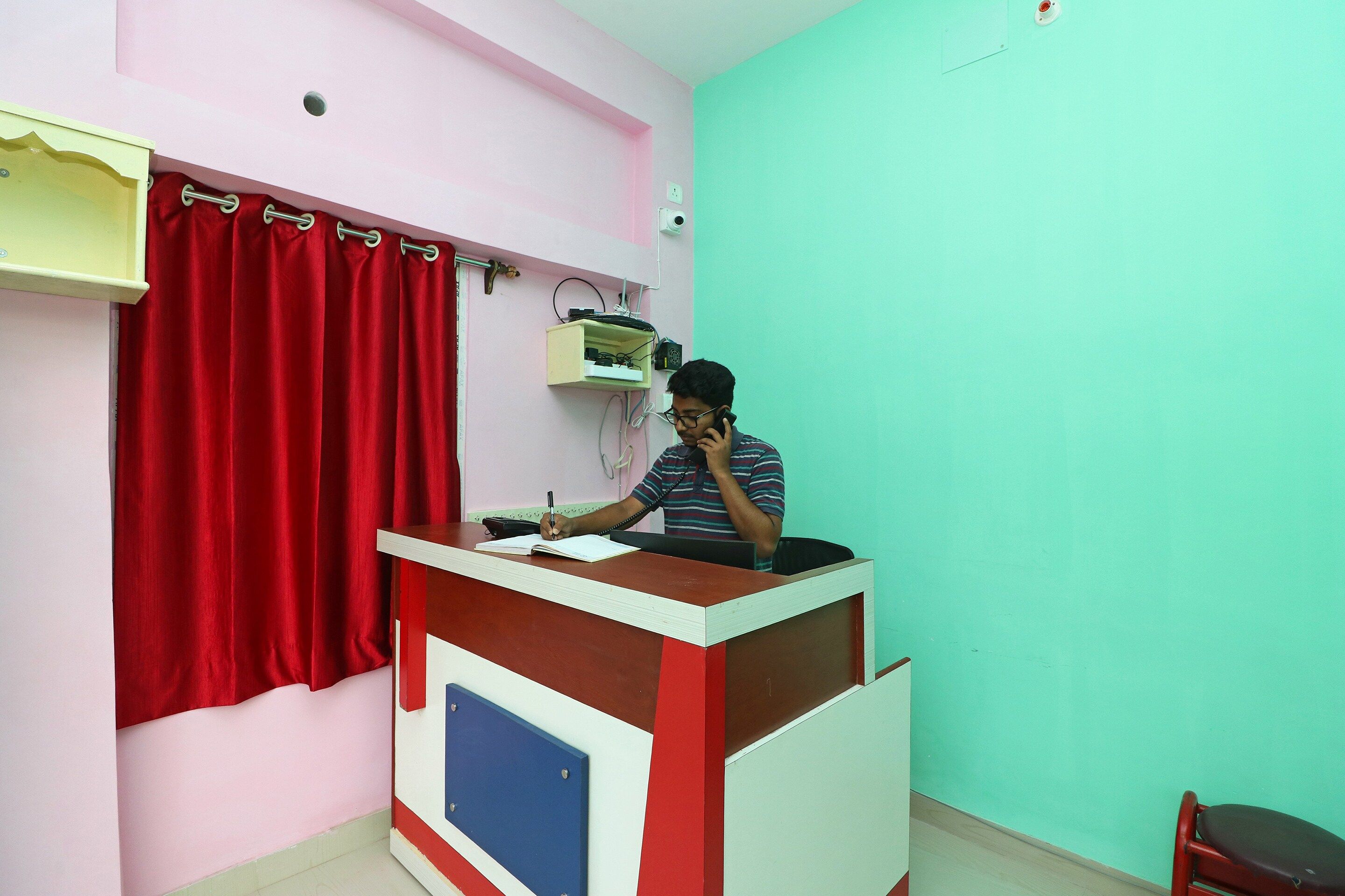A room with a desk, a telephone, and a chair.