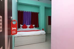 Una camera d'albergo con un letto, tende rosse e un cartello rosso appeso al muro.