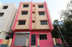 Un edificio de varios pisos con fachada plana, puerta de garaje cerrada y entrada protegida por una reja.