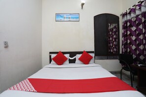 A bed with a white and red bedspread, two red pillows, and a picture of a bridge on the wall. - Hotel O Raviz Inn (Kolkata)