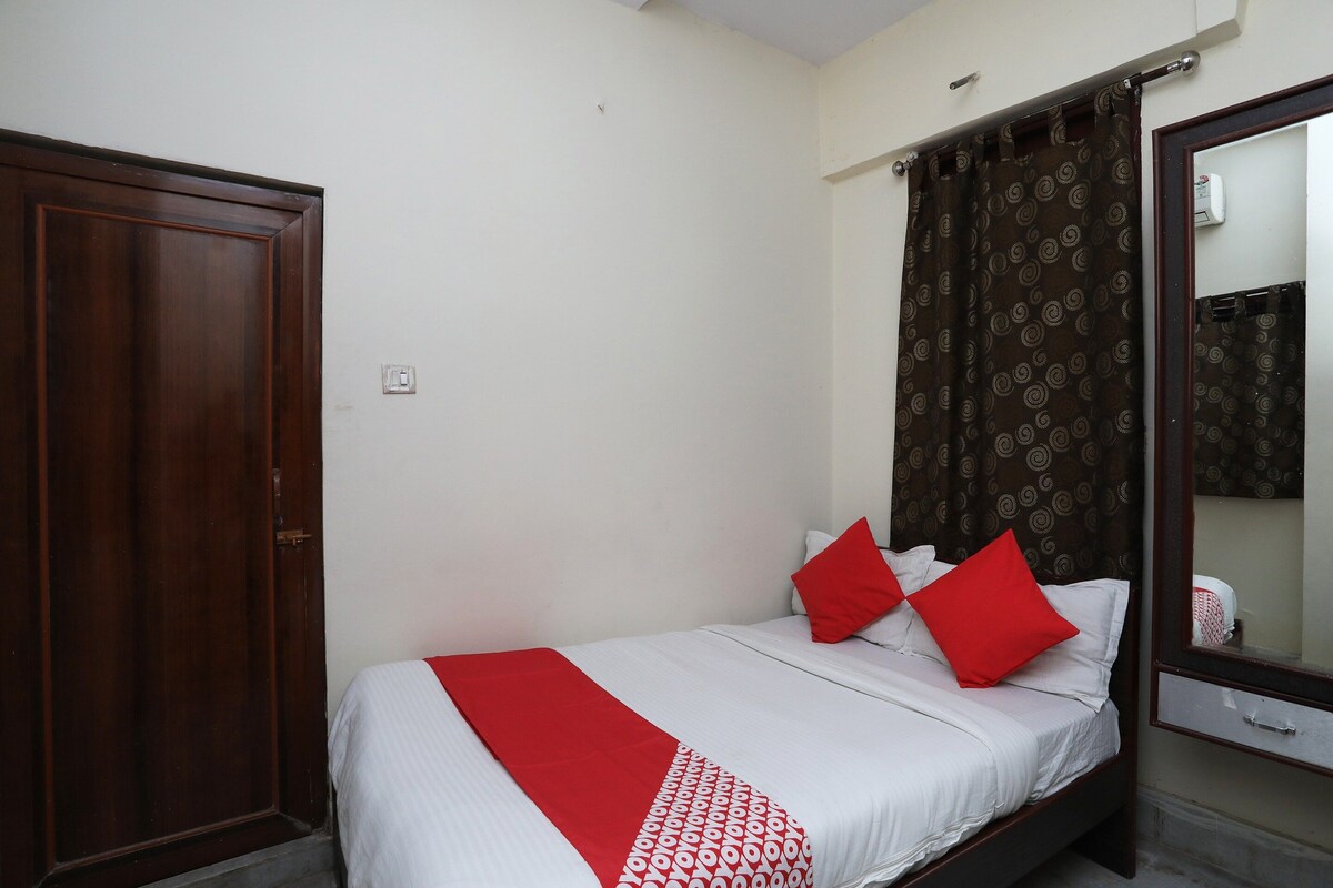 A bedroom with a bed, a wardrobe, and a mirror.