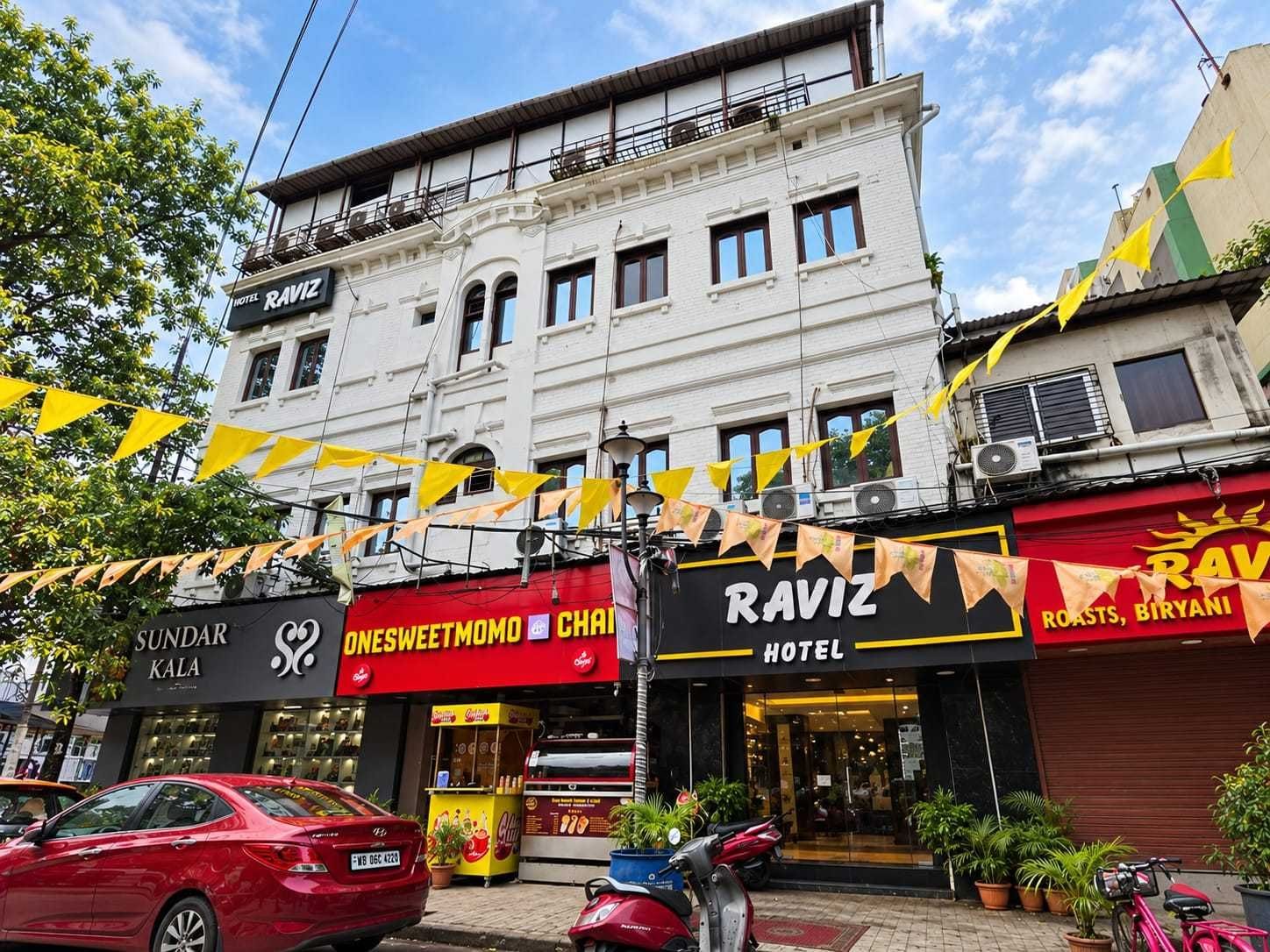 A hotel named RAVIZ with a signboard advertising 'ROASTS, BIRYANI' and a visible entrance.