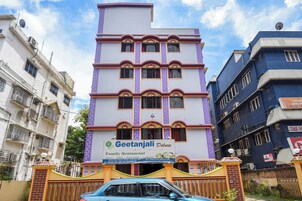 Un hotel de varios pisos con un letrero destacado para el Restaurante Familiar Geetanjali Deluxe.