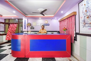 A reception desk with a clock, a sign for 'Reception', and a framed picture on the wall.