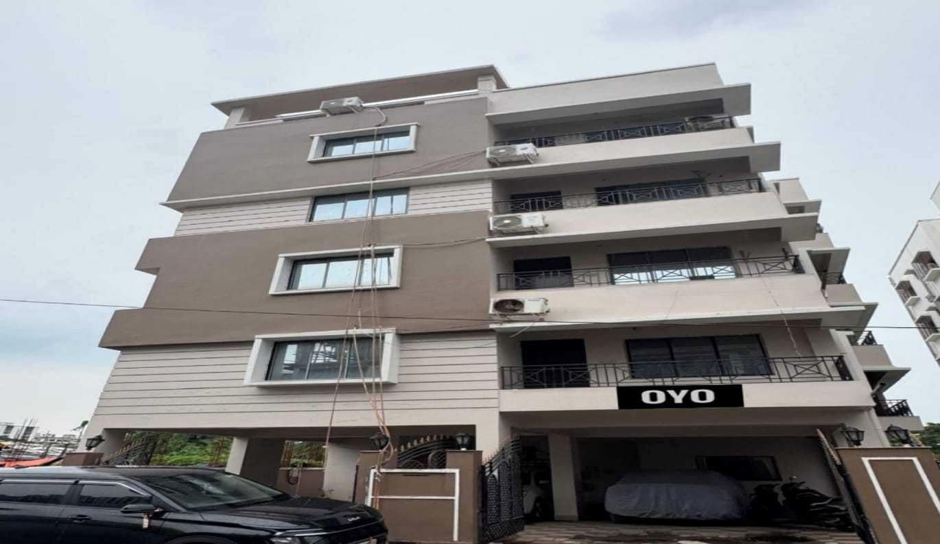 A multi-story building with a flat facade, balconies on each floor, and a sign that reads 'OYO'.