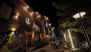 A restaurant with outdoor seating, a mural on the wall, and a sign for 'Cimson Restaurant'. - Tara Van Manali (Dobhi)