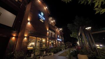 A brick building with a storefront and illuminated signage at night.