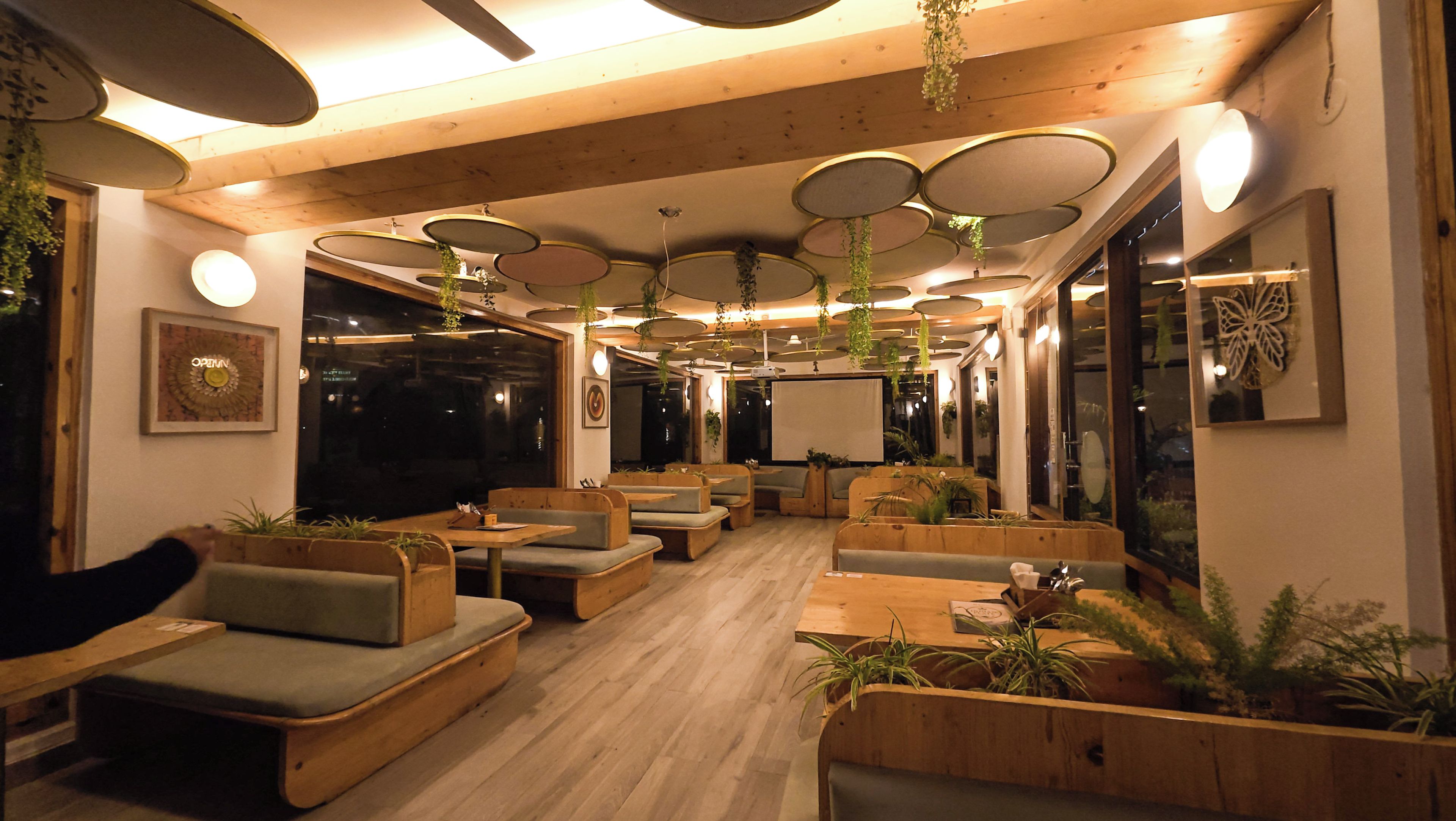 A cozy indoor seating area with wooden furniture and hanging plants.
