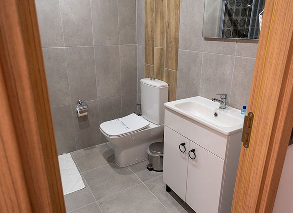 Un baño con inodoro, lavabo y armario.