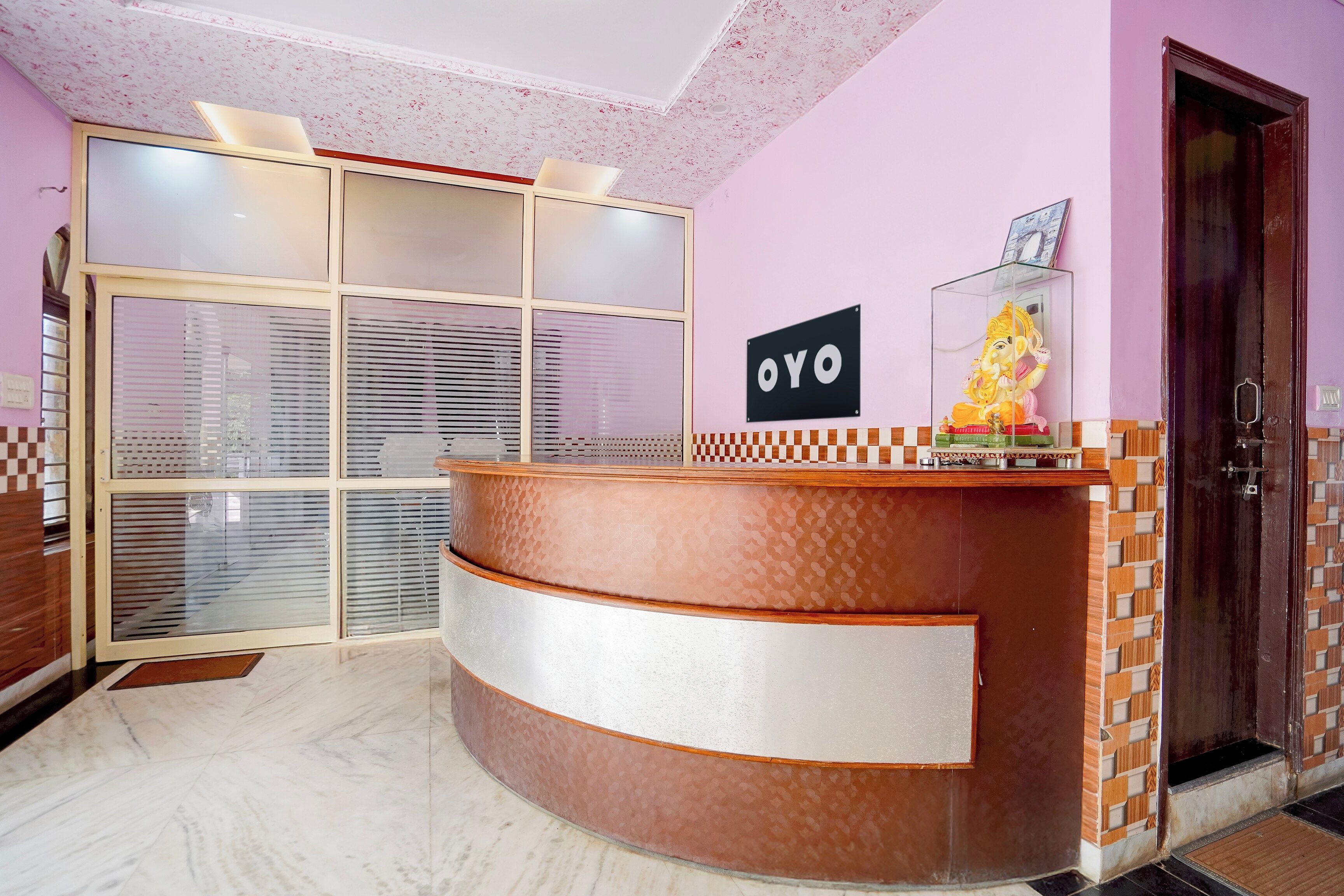 Un comptoir d’accueil avec une enseigne indiquant « OYO » et une statue d’une divinité.