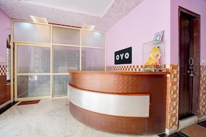 A reception desk with a sign reading 'OYO' and a statue of a deity. - Hotel O Devi Kripa (Mathura)