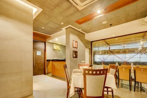 A hotel room with a dining area, a large window, and a view of the cityscape. - Collection O by OYO Suncity Premiere (Mumbai)