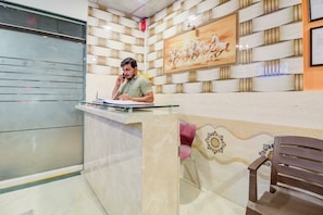 Un'area reception con un bancone in marmo, un quadro incorniciato di cavalli e una parete decorata.