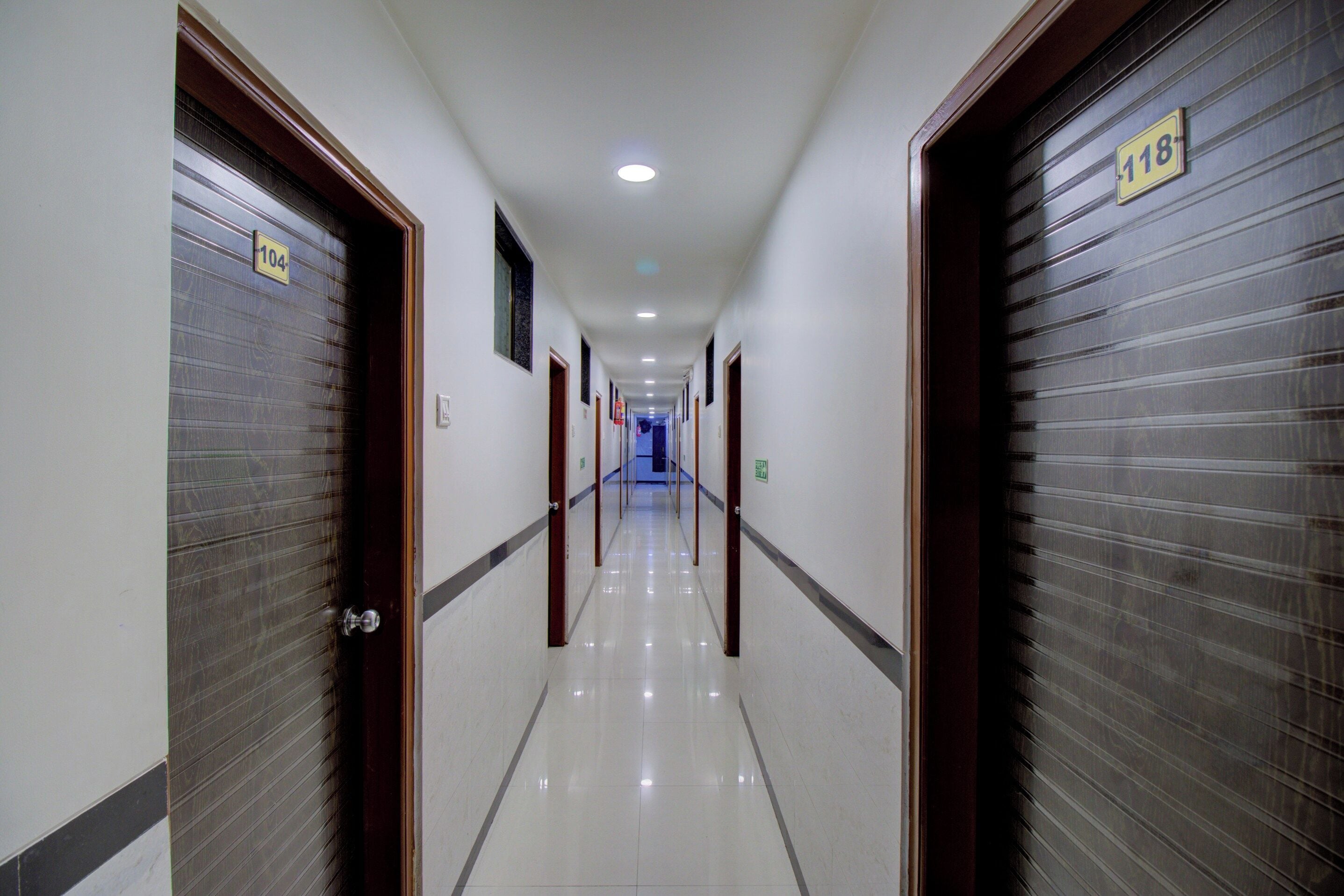 A hotel corridor with doors numbered 104 and 118, leading to rooms.