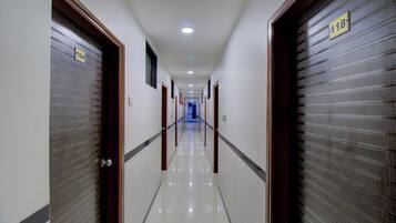 A hotel corridor with doors numbered 104 and 118, leading to rooms.
