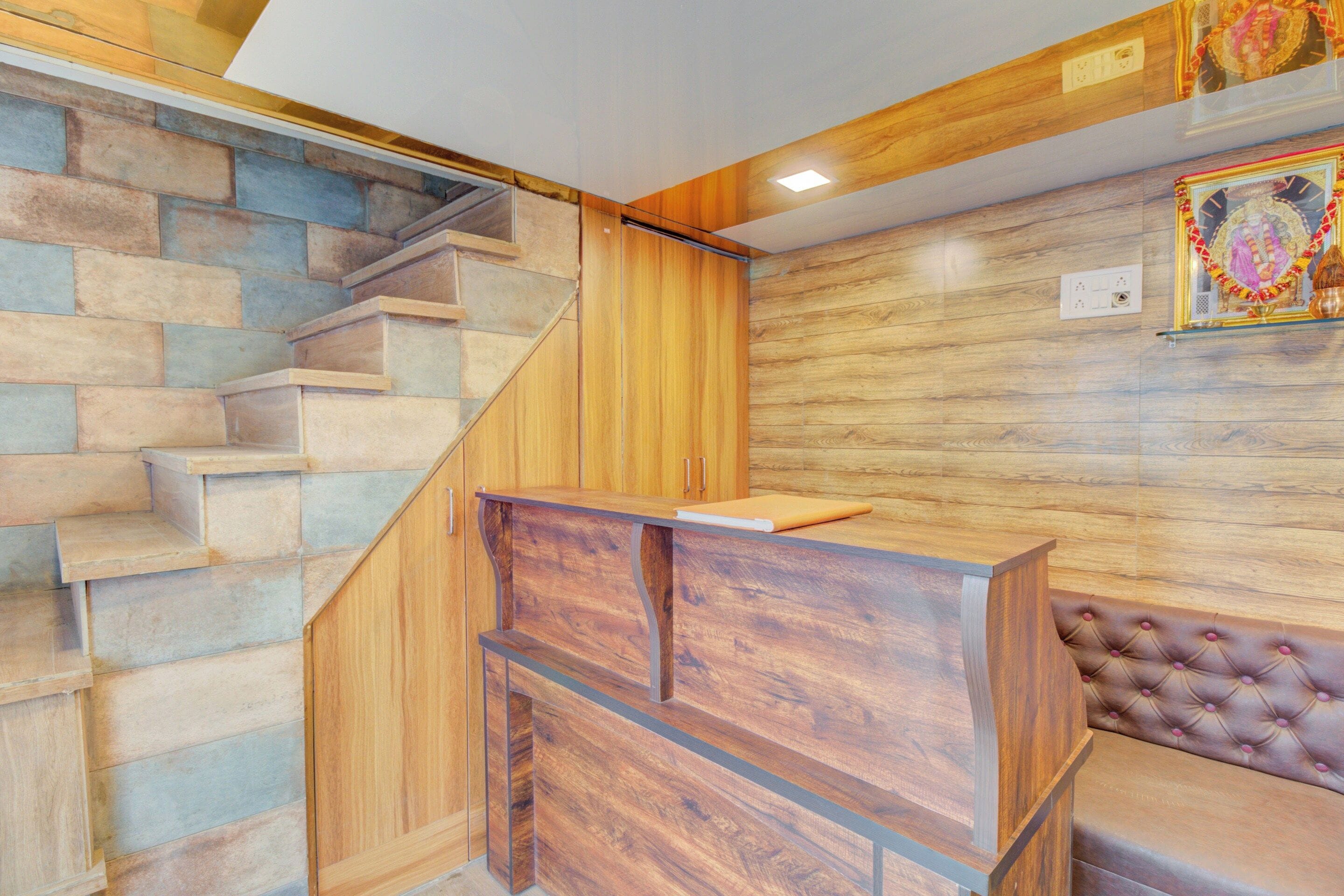 A staircase with a wooden finish, a reception desk, and a wall with a patterned design.