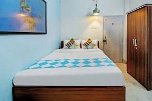 A hotel room with a bed, a wardrobe, and a door. - Hotel O Nilay Guest House (Kolkata)