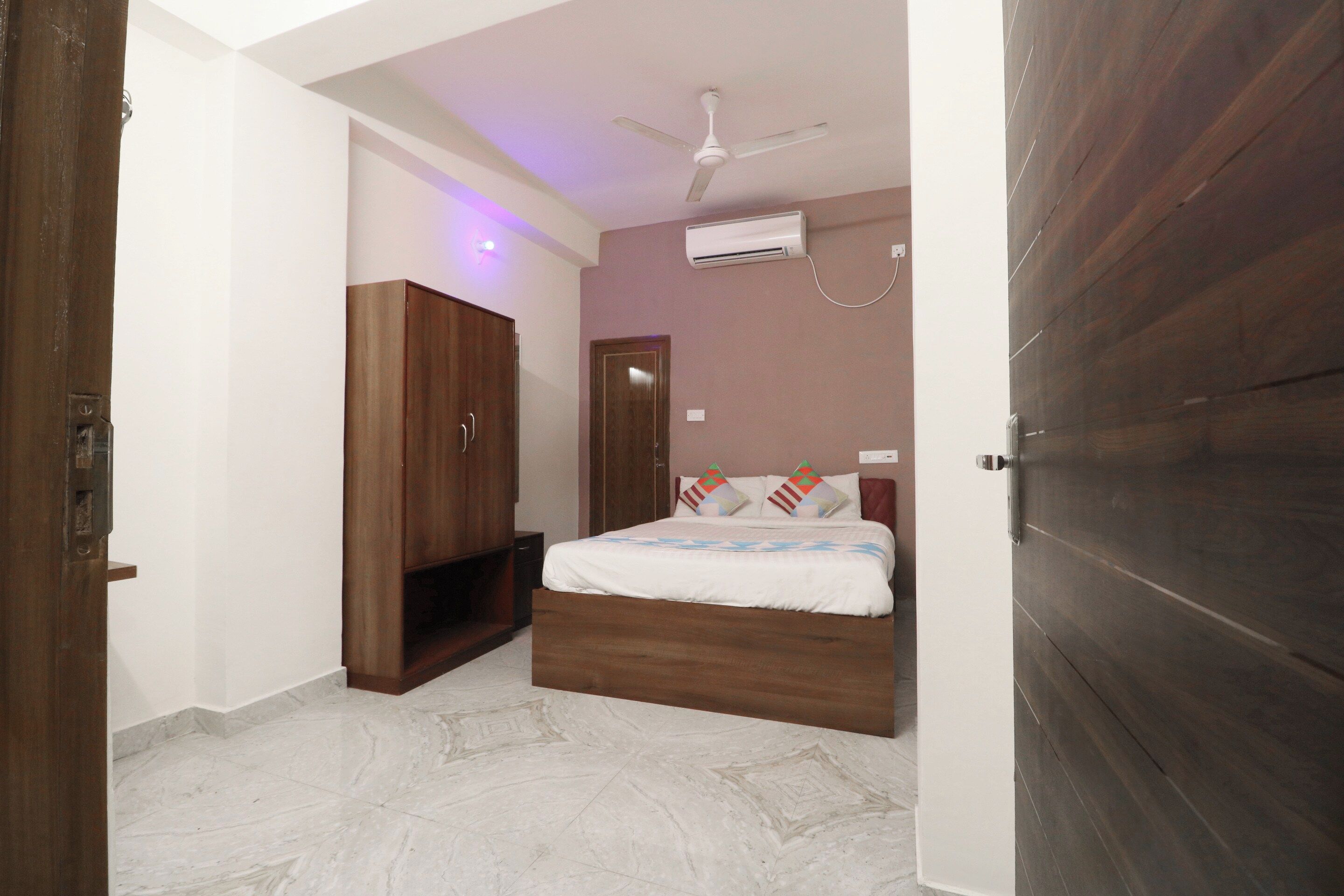 Un dormitorio con cama, armario, ventilador de techo y aire acondicionado.